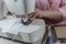 Woman sews a medical mask on the face on a sewing machine in the frame visible hands