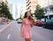 Woman in sexy stylish dress posing in the city with standing on the road