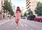 Woman in sexy stylish dress posing in the city with standing on the road