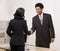 Woman shaking hands with co-worker at desk