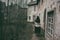 A woman with a shawl on her shoulders walks along the path of an old sad city in medieval Europe