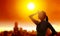 Woman shielding her eyes from sun with summer heat wave in the city background