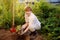 Woman shod in boots digs potatoes in her garden