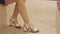 Woman in a shoes shop is measuring white sandals