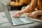 Woman shopper makes online purchases using laptop and credit debit cards while sitting on couch at home. Female hands with cards