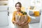 Woman with shopping bag full of fresh food indoors