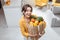 Woman with shopping bag full of fresh food indoors