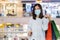 Woman shopping with bag at mall and her wearing medical mask for prevention from coronavirus Covid-19 pandemic. new normal