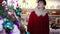 woman shopping christmas decorations for tree in market