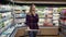 Woman shopping in supermarket while talking using mobile