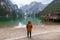 Woman on shore looking out at view of the mountain lake