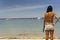 Woman in short jeans at back arriving beach with sunglasses