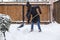 woman with shovel cleaning snow. Winter shoveling. Removing snow after blizzard