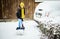 woman with shovel cleaning snow. Winter shoveling. Removing snow after blizzard