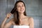 Woman after shower combing her healthy brown hair