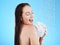 Woman in shower, laughing and happy with soap, hygiene and water drops with skincare on blue background. Washing