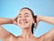 Woman, shower and smile in skincare for hygiene, hydration or water against a blue studio background. Happy female model