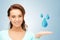 Woman showing blue water drops