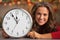 Woman showing clock in christmas decorated kitchen