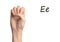 Woman showing letter E on background, closeup. Sign language
