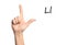 Woman showing letter L on background, closeup. Sign language