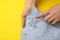 Woman showing shirt with stain on yellow background, top view. Space for text