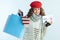 Woman showing shopping bags with sweaters and discount coupon