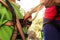 A woman shows a child how to use a carabiner for belaying