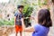 A woman shows a child how to use a carabiner for belaying