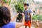 A woman shows a child how to use a carabiner for belaying