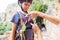 A woman shows a child how to use a carabiner for belaying