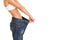 Woman shows her weight loss by wearing an old jeans, isolated on