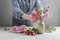 Woman shows how to make spring bouquet with tulip, hyacinth and carnation flowers