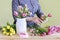 Woman shows how to make spring bouquet with tulip, hyacinth and carnation flowers, tutorial