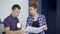 A woman shows a man working papers during a coffee break.