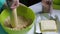 A woman shreds a biscuit with a rolling pin.