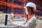 Woman sideways to camera working on laptop in warehouse