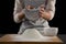 Woman sieving flour from the bowl on the wooden board