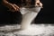 Woman sifting flour at grey table. Making pasta