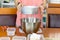 Woman sifts flour in a metal bowl preparing to bake a cake.