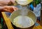 Woman sifts the flour in mixer bowl with wipping eggs. Making cake dough