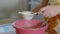 Woman sifts the flour through a sieve in the kitchen