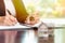 Woman signing real estate contract papers holding house keys and home keychain with small model home in front