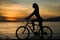 woman silhouette with bicycle with sunset and seat