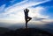 Woman silhouette practicing yoga position on mountain