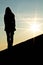 Woman silhouette standing on a wall in beautiful sunset