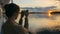 Woman silhouette taking photo of sunset with smartphone on deck of cruise ship