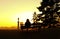 Woman silhouettes with bench on colorful orange urban sunset