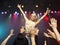 Woman singing in concert on stage in front of adoring fans low angle view