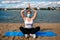 Woman in singular mask do yoga on the beach
